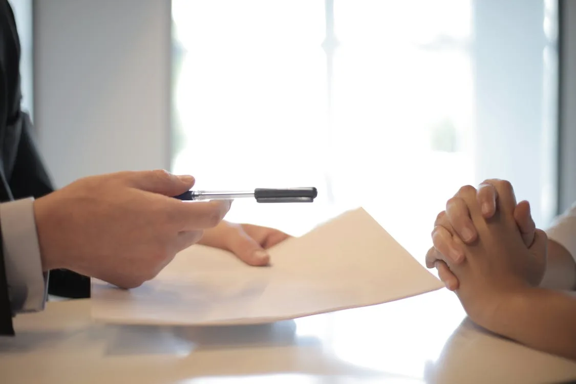 Person at a kitchen table organizing legal papers